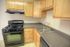 Charming modern kitchen with light wood cabinets, sleek countertops, and a gas stove.