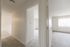 Bright apartment hallway with plush carpeting and two open doors leading to sunlit rooms.
