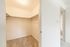 Spacious walk-in closet with ample shelving and soft carpet flooring, offering a perfect storage solution.