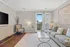 Bright and elegant living room with stylish decor, featuring a plush sofa, modern artwork, and large glass doors opening to a scenic balcony view.