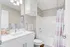 Elegant bathroom with a modern vanity, sleek fixtures, and a stylishly tiled bathtub area.
