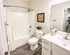 Modern bathroom with elegant fixtures, featuring a spacious vanity, sleek mirror, and inviting bathtub. Stylish decor and bright lighting enhance the room's sophisticated charm.