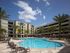 Lark Central Florida Exterior | Pool | Palm trees | Lounging Chairs | Table and chairs