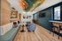 Modern lounge area with stylish decor, featuring elegant gold lighting fixtures, comfortable seating, and vibrant artwork on the ceiling and walls.