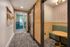 Stylish hallway featuring a chic woven wall hanging, modern lighting, and a cozy alcove with a round table and bench seating, combining elegance and comfort.