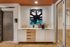 Chic refreshment station with modern cabinetry, stylish wall art, and a fully stocked coffee machine, perfect for an inviting gathering space.