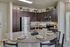 Modern kitchen with sleek granite countertops, stainless steel appliances, and stylish dark wood cabinetry, perfect for culinary enthusiasts.