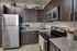 Modern kitchen with sleek stainless steel appliances, rich wooden cabinets, and elegant granite countertops.