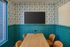 Charming meeting space featuring modern teal paneling, warm wooden table, and elegant leather chairs, ideal for creative sessions.
