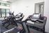Modern gym with state-of-the-art treadmills and exercise bikes, well-lit space with large windows.
