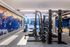 Contemporary fitness center with state-of-the-art gym equipment, vibrant sports mural, and sleek design.