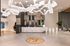 Elegant apartment lobby showcasing a modern reception desk with marble finish, unique sculptural lighting, and luxurious seating area.