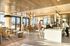 Modern and inviting communal space with stylish seating, elegant lighting, and large windows offering abundant natural light.