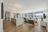 Modern open-concept apartment with elegant kitchen island, cozy living area, and large windows offering natural light and scenic views.