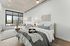 Bright and modern studio apartment with stylish furniture, large window, and cozy seating area, offering a welcoming and versatile living space.