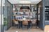 A reading nook in the demo kitchen of One Rangers Way featuring a library of books, sleek leather seating, and a black pendant lights