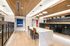 Sophisticated mailroom with elegant wooden ceiling, designer lighting, and sleek black mailboxes alongside a stylish marble counter.