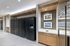 Modern apartment lobby featuring secure Luxer One package lockers and stylish decor with framed art.