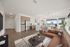 Modern open-concept living space with elegant kitchen, cozy seating, and expansive windows offering a scenic view.