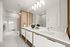 Luxurious modern bathroom with sleek double sink, elegant lighting, and marble finishes.