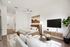 Elegant studio apartment with modern decor featuring a cozy bed, stylish wall art, sleek TV console, and vibrant indoor plant.