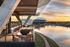 Luxurious balcony with modern seating overlooking a serene river at sunset, complemented by a views of AT&T Stadium.