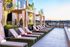 Luxurious rooftop patio with chic cabanas and stylish lounge chairs offering scenic views at sunset.