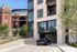 Contemporary apartment complex with parking, adjacent to a prominent stadium and lush greenery.