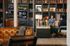 Chic apartment lobby featuring cozy seating, elegant bookshelves, and a flat-screen TV, perfect for social gatherings.