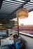 Chic rooftop lounge with cozy seating, ambient lighting, and a view of a sports stadium, perfect for relaxation and entertainment.