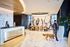 Modern lobby with sleek marble floors, artistic wall design, welcoming reception, and a guest walking a dog.