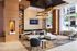 Elegant and modern lounge area in a luxury apartment building, featuring chic seating, a stylish chandelier, and large windows offering plenty of natural light.