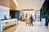 Luxurious apartment lobby with elegant marble flooring, stylish reception desk, and eye-catching modern artwork, offering a welcoming and sophisticated atmosphere.