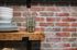 brick backsplash and exposed shelving in a studio apartment