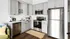 Contemporary kitchen with grey cabinets, stainless steel appliances, and a cozy corner setup.