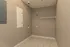 Spacious utility room with sleek tiled flooring, perfect for a washer and dryer setup, featuring built-in wall storage and a convenient shelf.