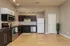 Modern kitchen with sleek dark cabinets, stainless steel appliances, and elegant wood flooring.