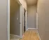 Bright and inviting hallway with warm wood flooring, offering access to multiple rooms, perfect for a modern apartment.