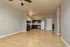Spacious open-concept apartment with modern kitchen, sleek hardwood floors, and stylish lighting.