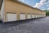 Modern apartment complex featuring a row of single-car garages with a sleek beige exterior, offering ample parking space and convenience for residents.