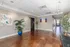 Bright, inviting lobby with elegant tile flooring, vibrant artwork, and lush greenery, offering a welcoming atmosphere.