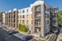 Modern apartment building with stylish balconies and ample parking in a serene neighborhood setting.
