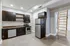 Modern kitchen with sleek dark cabinets, stainless steel appliances, and a convenient ladder to a loft space, perfect for stylish living.