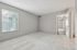 Bright and airy bedroom with soft carpeting, large window for natural light, and a clean, modern design at Driscoll Place Apartments.