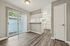 Bright and modern kitchen with sleek white cabinetry, an inviting breakfast bar, and elegant hardwood floors opening to a sunlit patio at Driscoll Place.