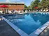 Hidden Creek Apartments Pool| Inviting outdoor pool area with comfortable lounge chairs, vibrant red umbrellas, and a serene atmosphere ideal for relaxation.