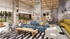 Modern living room with chic decor, featuring a cozy blue sofa, stylish wooden coffee table, and contemporary lighting, overlooking a lush garden through large windows.