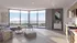 Bright, modern open-concept living room and kitchen with panoramic windows and stylish decor, offering stunning views of greenery.
