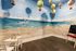 Charming playroom with a vibrant beach mural featuring seagulls and dunes, complemented by floating hot air balloons.