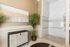 Elegant bathroom featuring modern walk-in shower, stylish artwork, and lush green plant for a touch of nature.